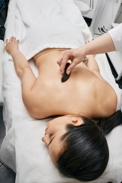 istock Gouache massage. Doctor doing a physical effect on woman's body using a gouache scraper for increased blood and lymph flow 1311483942