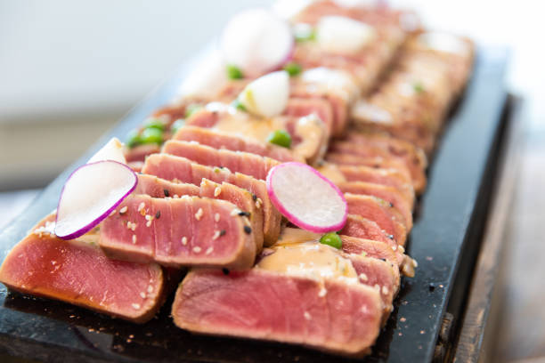 indoor with window light view of a freshly sliced raw tuna steak served at a buffet