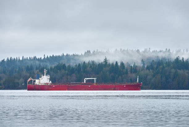 An oil tanker anchored in a misty Burrard Inlet. Vancouver, British Columbia, Canada.