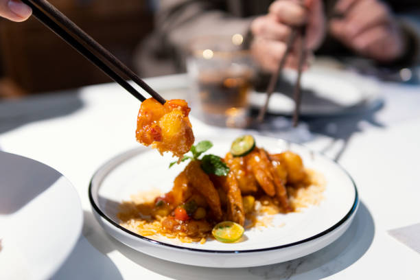 istock Eating Sweet and Sour Prawn Balls with chopsticks 1311486554