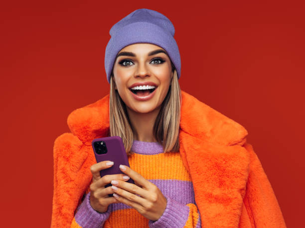 istock Beautiful woman standing with smart phone 1311490032