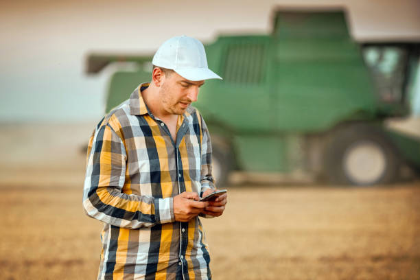 istock Farmer using phone on agriculture field 1311494671