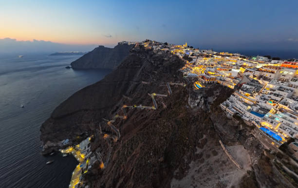 panorama aéreo noturno grande da cidade de fira (thira) ao pôr do sol, ilha de santorini, grécia - landmarks roof staircase landscape - fotografias e filmes do acervo