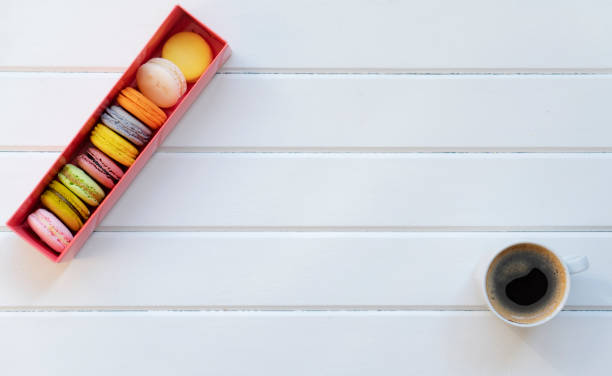 coffee, cake macaron and flower on wood