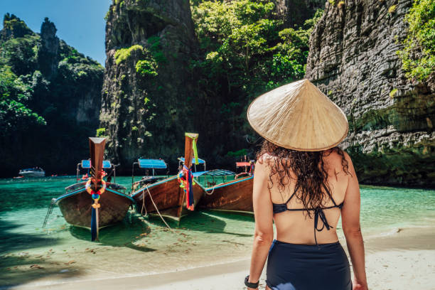 istock Young woman on a beautiful beach in Thailand with longtail boats, Phi Phi Island 1311496599