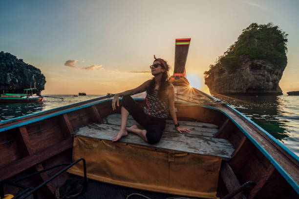 istock Young woman on a longtail boat in Thailand during sunset, Phi Phi Island 1311496630