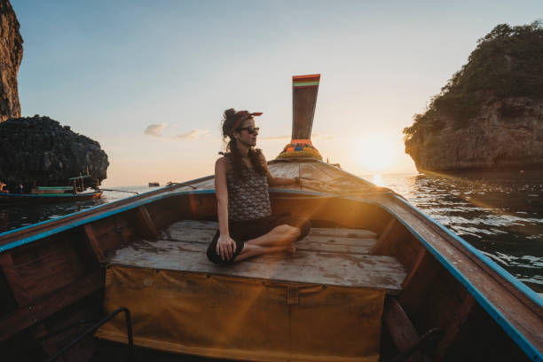 istock Young woman on a longtail boat in Thailand during sunset, Phi Phi Island 1311496632