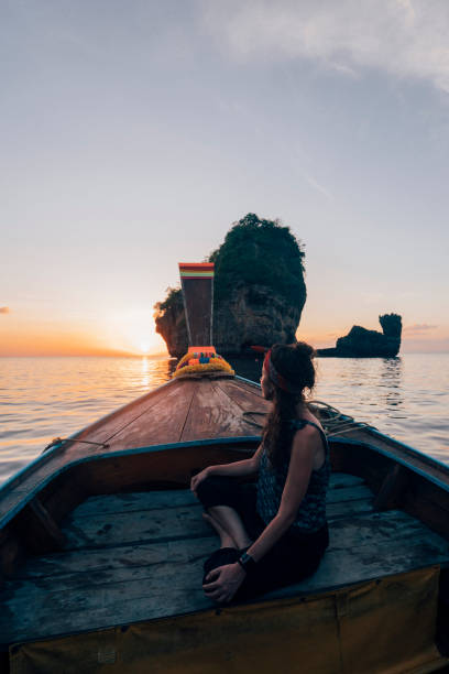 istock Young woman on a longtail boat in Thailand during sunset, Phi Phi Island 1311496636