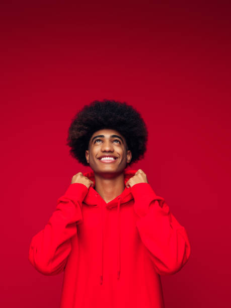 고립 된 빨간 배경 위에 서 아프리카 헤어 스타일을 가진 아프리카 계 미국인 남자 - photography vertical color image studio shot 뉴스 사진 이미지