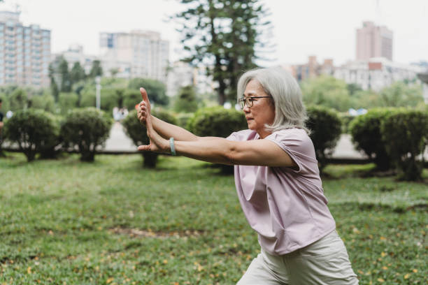 senior lady practicing yoga at the public park - women yoga yoga class mature adult imagens e fotografias de stock