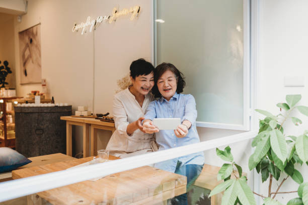 istock Two mature ladies using phone together at the cafe 1311501829