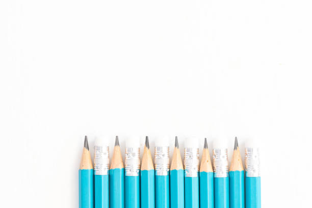 Three blue-painted lead pencils are crossed and stacked, with a matching pencil sharpener, on a paler blue background.