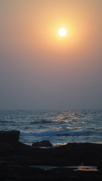 istock Sunset Blue Orange Red Yellow Waves Stones 1311503288