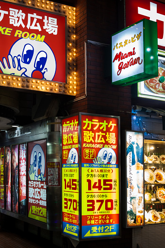 Vertical view of the flashy neon signs of a karaoke room in Shibuya Center-gai, Shibuya district, Tokyo