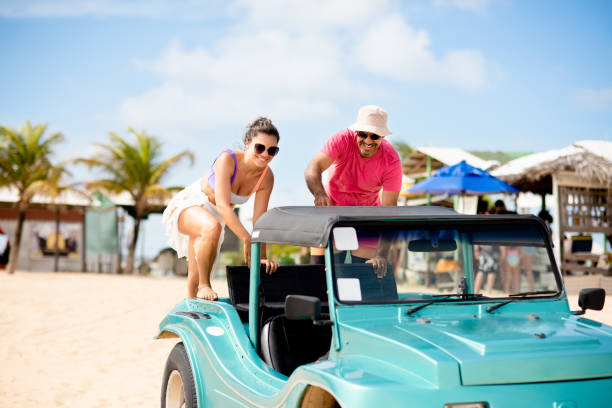 istock Smiling couple getting into a beach buggy in the summer 1311505865