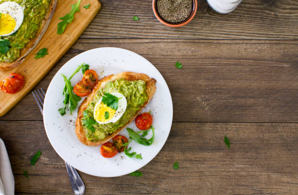 tostadas de aguacate con huevos y tomates asados - salad breakfast cooked eggs fotografías e imágenes de stock