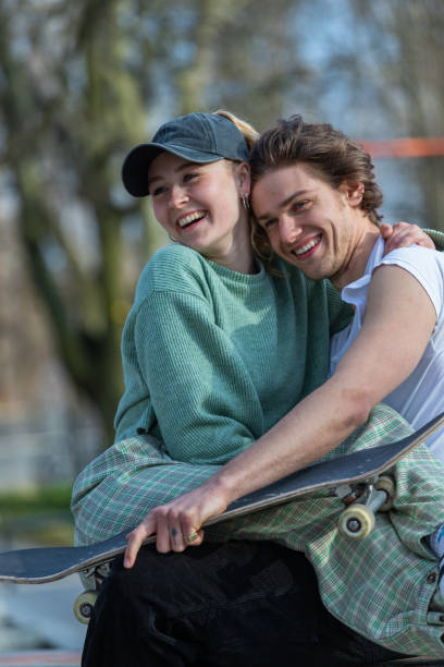 istock girlfriend sat on boyfriends lap at the skatepark 1311507331