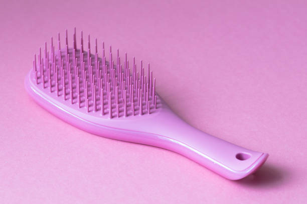 Pink hairbrush isolated on pink background