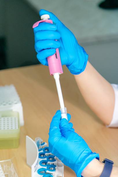 istock laboratory assistant in blue gloves picks up liquid from a test tube 1311508238