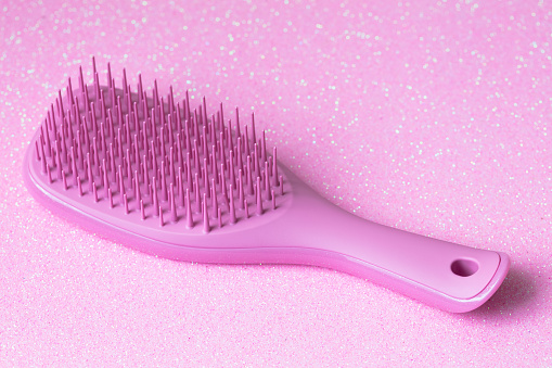 Pink hairbrush isolated on pink background