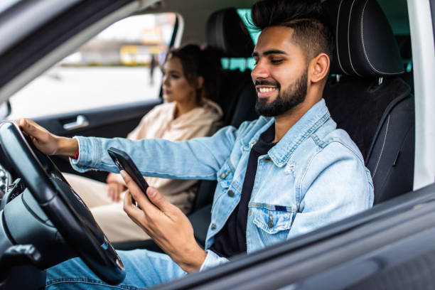 istock Traveler young indian couple use smart phone while driving car 1311508532