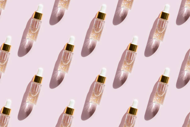 istock Seamless pattern of serum in bottle on pastel pink background. 1311510341