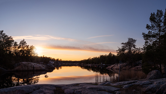 Panorama view of sunset in the Swedish archipelago. Rocks, calm water and coastal features this tranquil evening. Photo taken outside Oskarshamn, Sweden