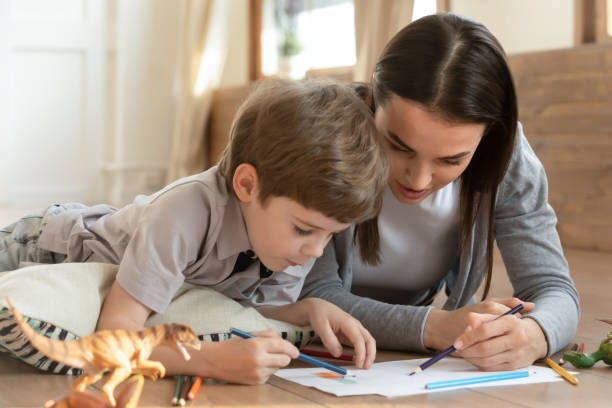 istock Caring young mother and small son playing drawing 1311511335