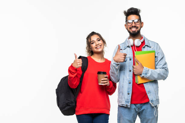 istock Young indian students with backpacks and books making thumb up gestures isolated on white background 1311512307