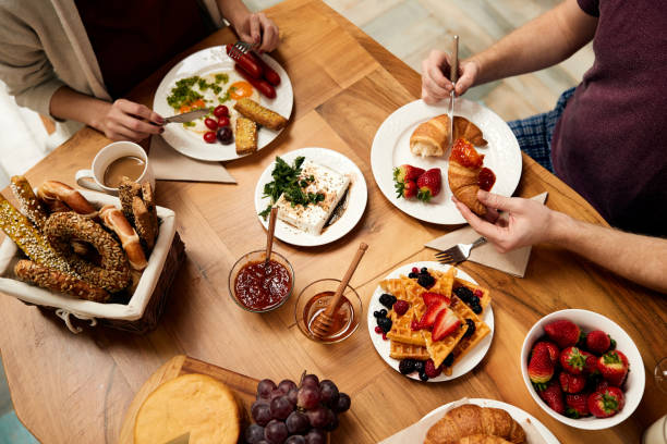 istock Unrecognizable couple eating breakfast at dining table in the morning. 1311512564