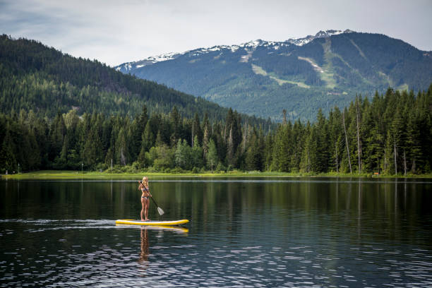 Paddleboarding on warm spring day in Whistler. stock photo