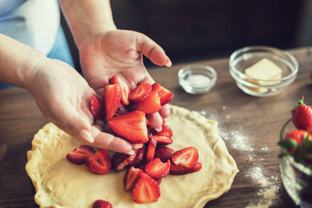 istock Young woman preparing strawberry galette or open strawberry pie 1311513751