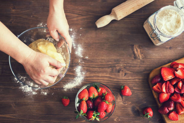 Young woman preparing strawberry galette or open strawberry pie
