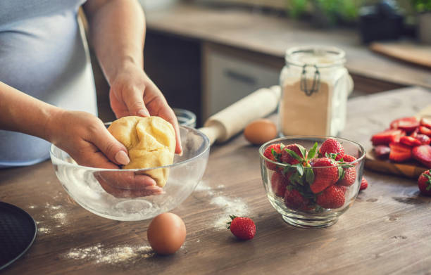 Young woman preparing strawberry galette or open strawberry pie