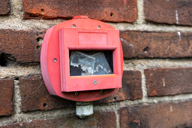 istock Hand fire alarm with broken glass on brick wall 1311514370