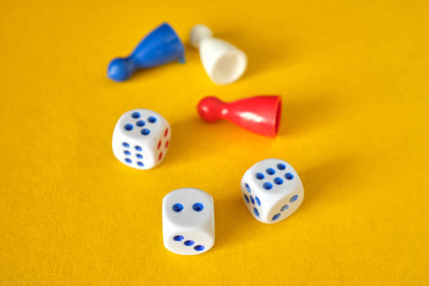istock Colored game figures chips for board games. Collection of dice cubes on yellow table. 1311515105