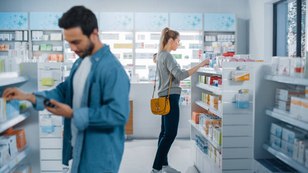 istock Big Moder Pharmacy Drugstore: Diverse Group of Multi-Ethnic Customers Browsing, Searching, Comparing Medicine Packages, Drugs Boxes, Pill Vitamins, Supplements, Purchasing Health Care Products. 1311515462
