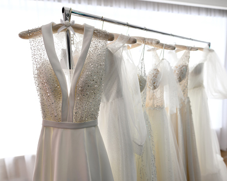 Wedding dresses hang on a hanger in the store or wedding showroom