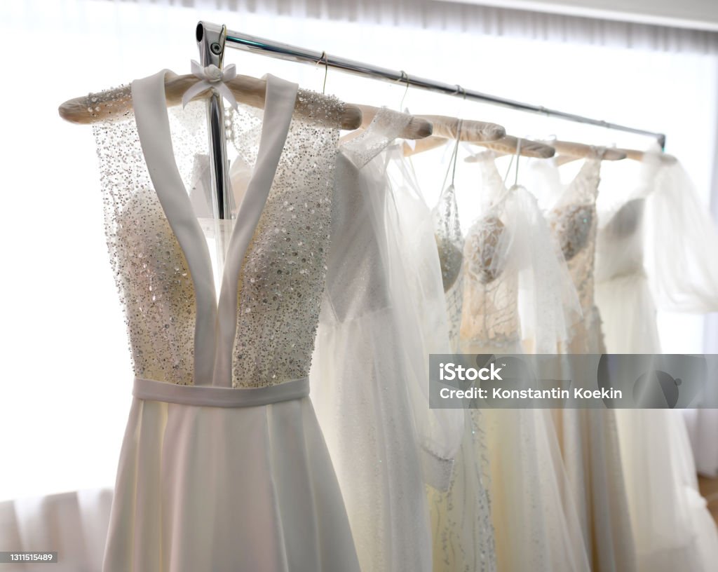 Wedding dresses hang on hanger in the wedding showroom Wedding dresses hang on a hanger in the store or wedding showroom Wedding Dress Stock Photo