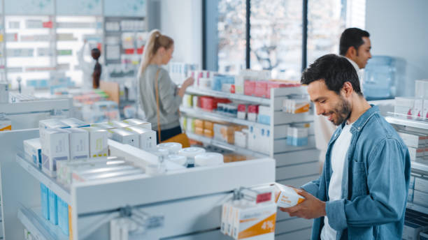 istock Big Moder Pharmacy Drugstore: Diverse Group of Multi-Ethnic Customers Browsing, Searching, Comparing Medicine Packages, Drugs Boxes, Pill Vitamins, Supplements, Purchasing Health Care Products. 1311515569