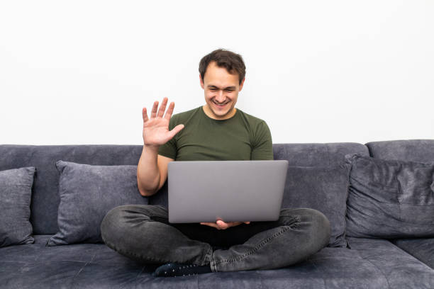istock Friendly happy young man waving hand saying hello looking at camera greeting distant friend making online call, cheerful male vlogger blogger recording vlog teaching e-coaching via webcam 1311516740