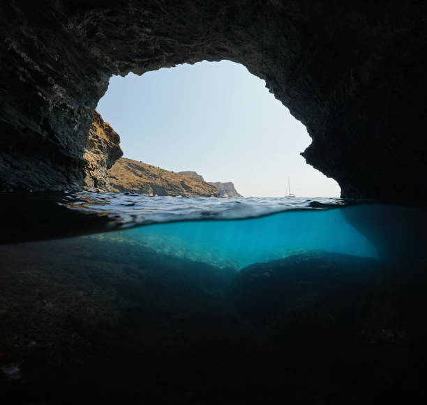 istock Rocky coast inside a cave over and under water 1311516761