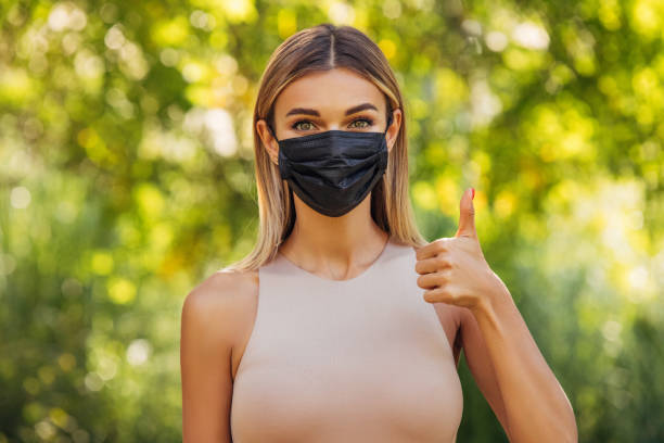 istock Girl in black protective mask showing thumb up 1311516958