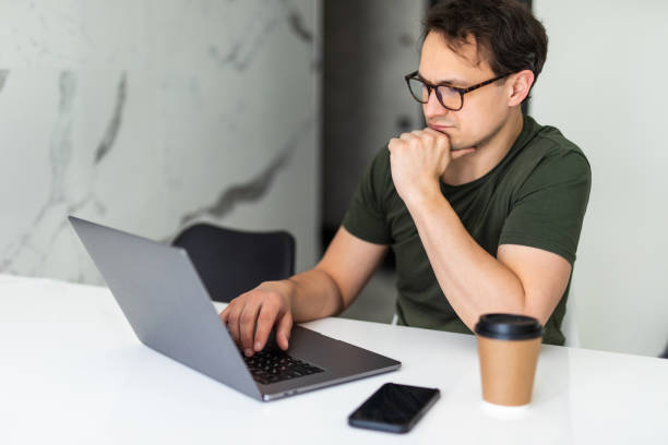 istock Handsome man using a laptop pc in the kitchen. Working from home in quarantine lockdown. Social distancing Self Isolation 1311517790
