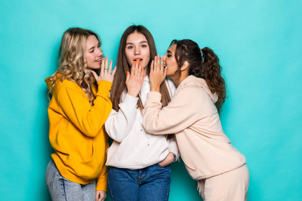 istock Three attractive girls gossiping isolated on turquoise background 1311521734