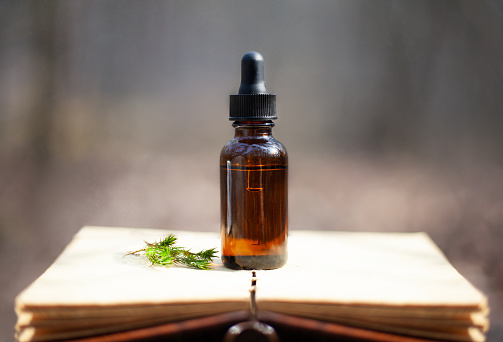 Essential oil bottle and aromatherapy, blank old notebook. Depth of field and bokeh.