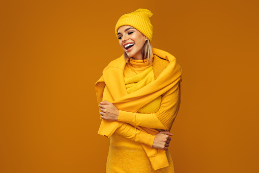 Portrait of a young woman wearing yellow sweater and hat