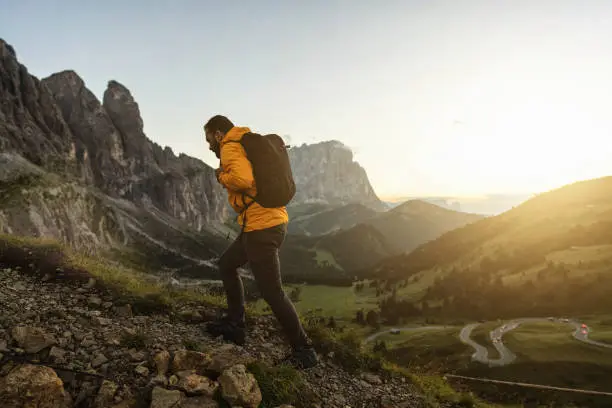 Photo of Man mountain hiking at sunset on the Dolomites: outdoor adventure
