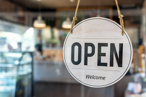 Open. coffee cafe shop text on vintage sign board hanging on glass door in modern cafe shop reopen after coronavirus quarantine is over in restaurant ready to service, small business owner concept