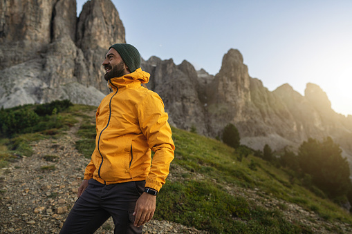 Man mountain hiking at sunset on the Dolomites: post pandemic outdoor adventure